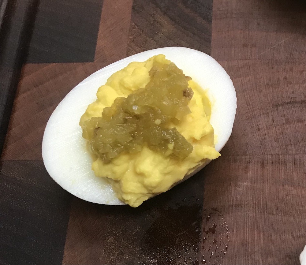 Deviled egg topped with jalapeño relish